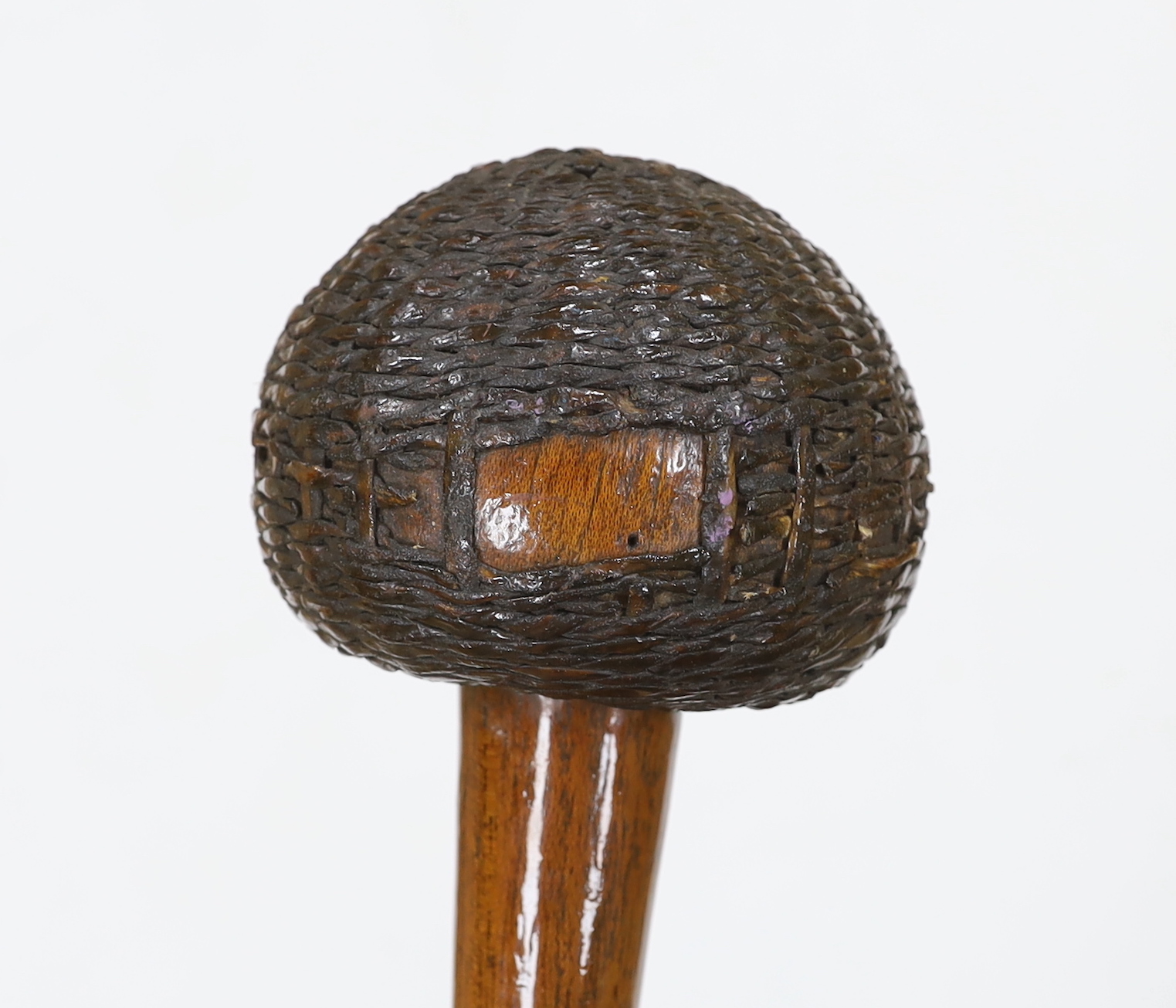 An African carved wooden club in the form of a knobkerry, with swollen head covered in basket weave